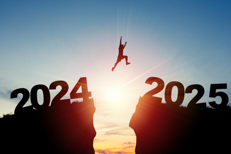 Welcome merry Christmas and happy new year in 2025,Silhouette Man jumping from 2024 cliff to 2025 cliff with cloud sky and sunlight.